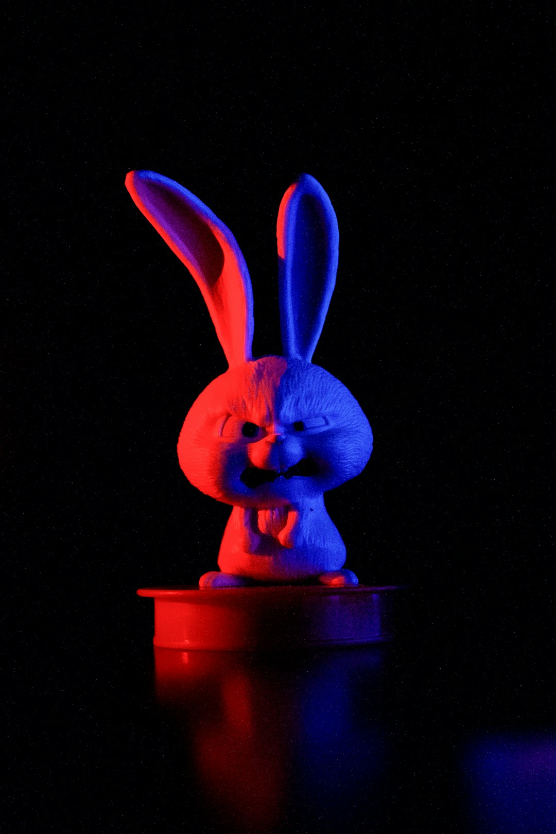 a-blue-and-red-rabbit-statue-sitting-on-top-of-a-table-zlb8igztxcm